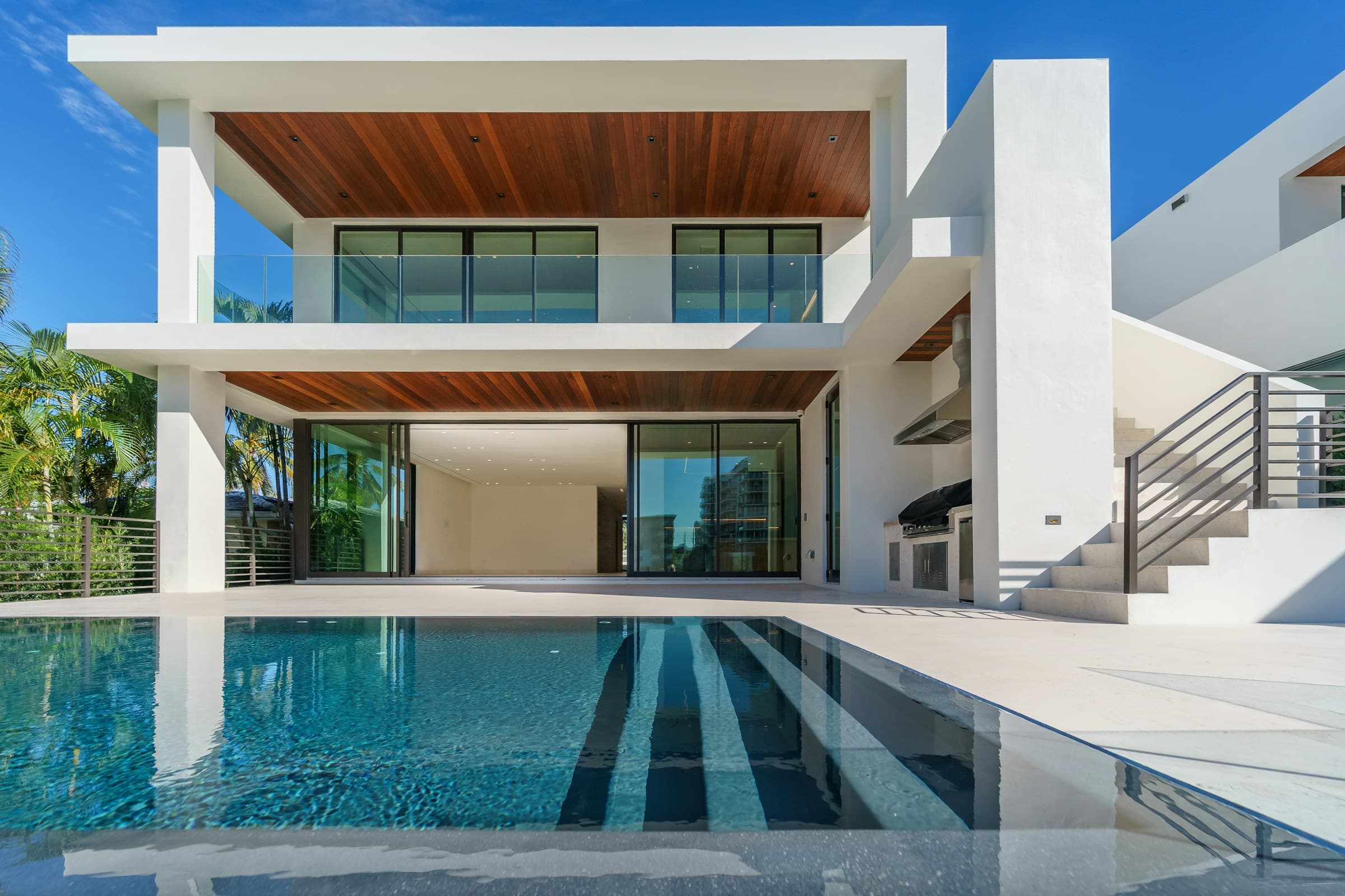 Contemporary villa courtyard with infinity pool, timber soffits and tropical planting — atmospheric brand photography, not a Bali Considered client project